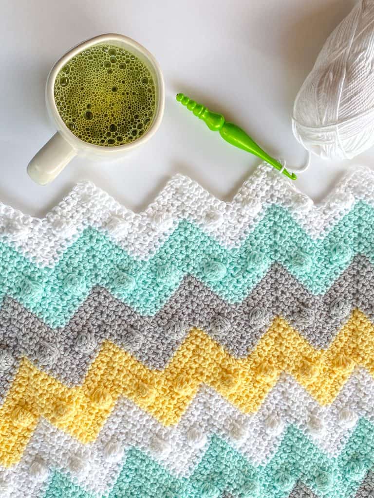 Beginner-friendly bobble chevron baby blanket crochet pattern makes the perfect baby shower gift! With my easy-to-follow video tutorial, you'll have your blanket done in no time! Stroller-sized newborn blanket with instructions to make in any size. Using I Love this Cotton yarn from Hobby Lobby. 