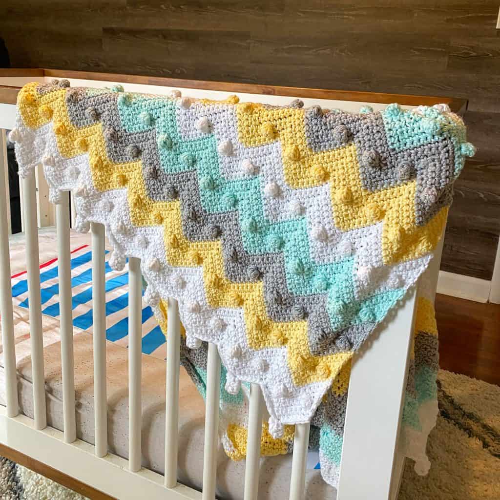 Beginner-friendly bobble chevron baby blanket crochet pattern makes the perfect baby shower gift! With my easy-to-follow video tutorial, you'll have your blanket done in no time! Stroller-sized newborn blanket with instructions to make in any size. Using I Love this Cotton yarn from Hobby Lobby. 