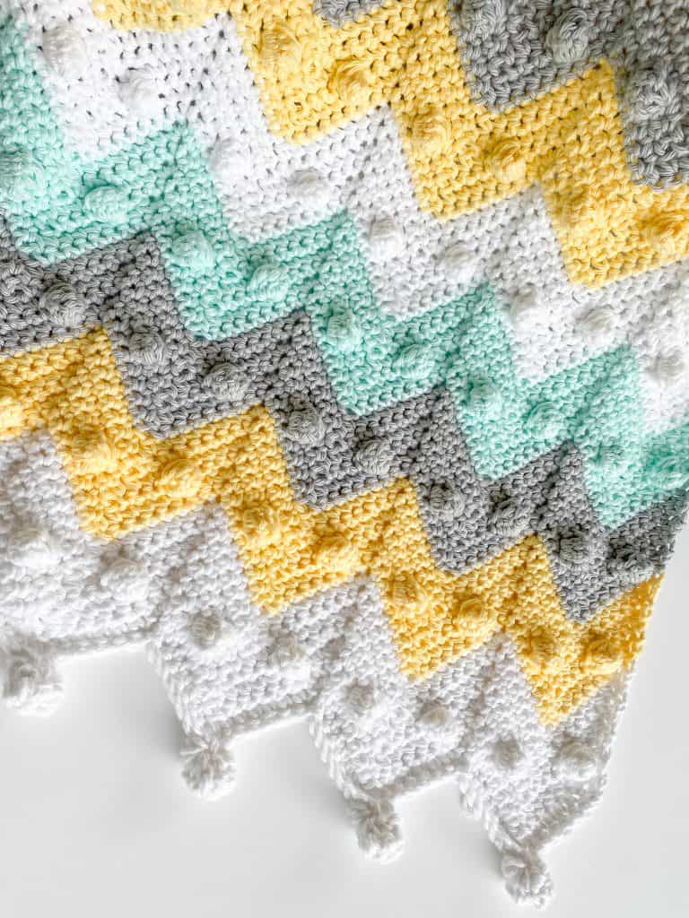 Beginner-friendly bobble chevron baby blanket crochet pattern makes the perfect baby shower gift! With my easy-to-follow video tutorial, you'll have your blanket done in no time! Stroller-sized newborn blanket with instructions to make in any size. Using I Love this Cotton yarn from Hobby Lobby. 