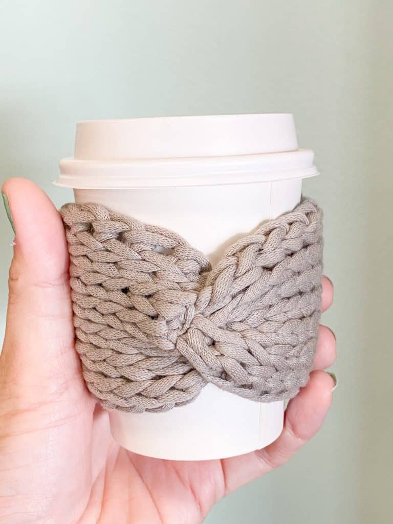 Looking for a stylish eco-friendly alternative to the paper coffee sleeve? Look no further than my Tunisian Knit Bow Coffee Sleeve pattern. This FREE easy crochet pattern is perfect for the eager beginner wanting to try Tunisian Crochet. Plus it uses a regular 10mm crochet hook and only 1/2 an ounce of Bernat Maker Home Dec Yarn. Fits any size coffee cup (from 8oz to 20oz).