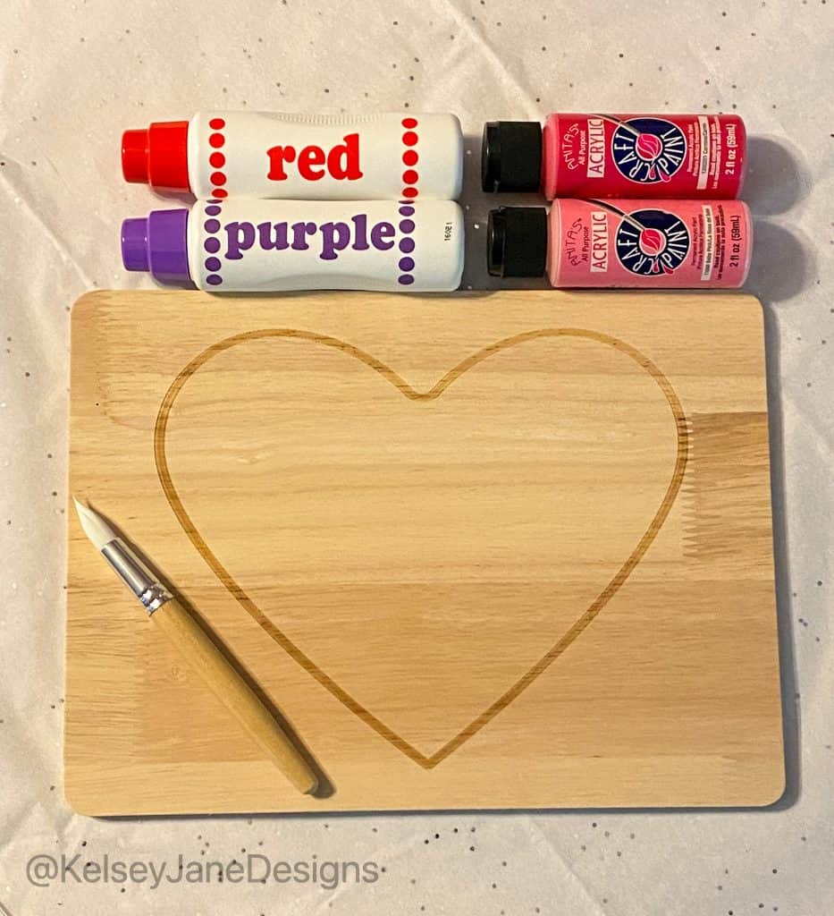 Super simple DIY handprint, or footprint, Valentine's Day home decor project that's toddler approved! Using the heart charcuterie boards from Target's Bulleyes Playground, paint and dot markers. You'll quickly have a wonderful Valentine's Day gift for grandparents or loved ones. 