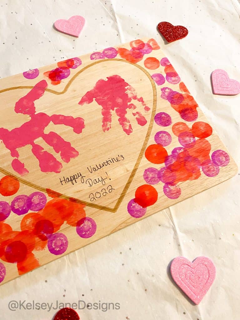 Super simple DIY handprint, or footprint, Valentine's Day home decor project that's toddler approved! Using the heart charcuterie boards from Target's Bulleyes Playground, paint, and dot markers. You'll quickly have a wonderful Valentine's Day gift for grandparents or loved ones. 