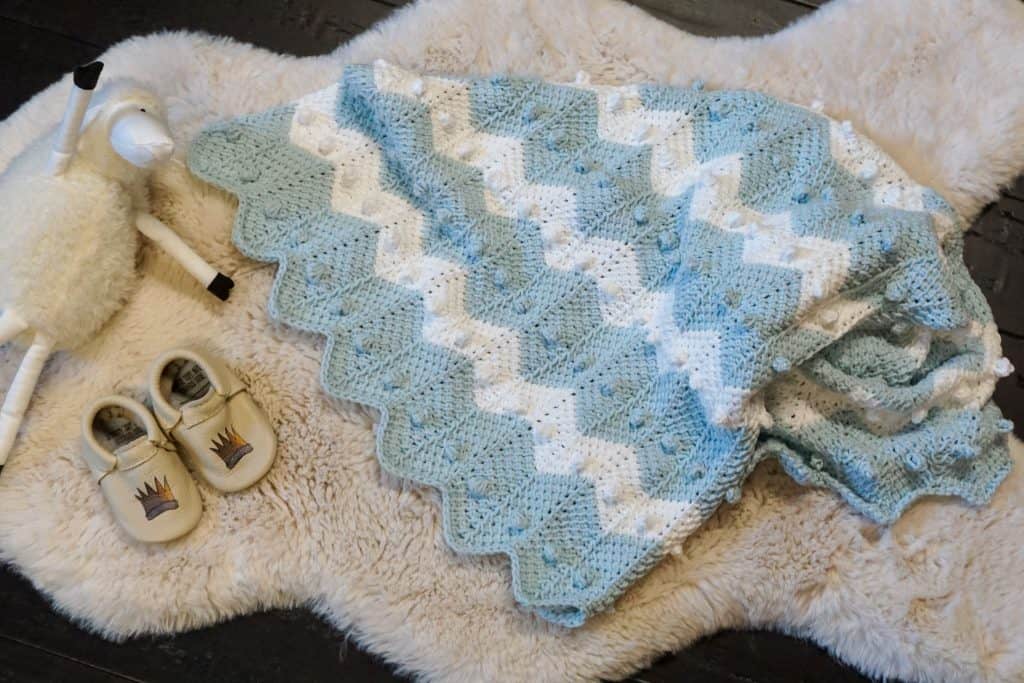 Learn how to crochet the bobble chevron baby blanket using tunisian crochet! If you can crochet a bobble and the tunisian simple stitch this will be super easy! Using Lion Brand's Feels Like Butta yarn. 