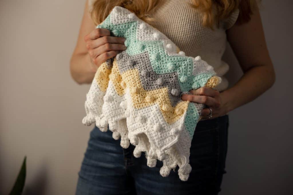 Learn how to crochet this timeless bobble chevron baby blanket with step by step instructions and YouTube video tutorial. 